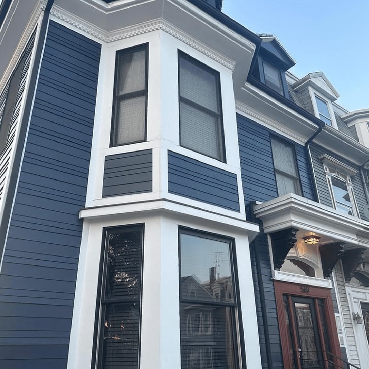 This is an image from CertaPro Painters of Andover, Massachusetts. It shows the exterior of a home with fresh navy blue siding accented by crisp white trim, highlighting the company’s expertise in residential exterior painting.