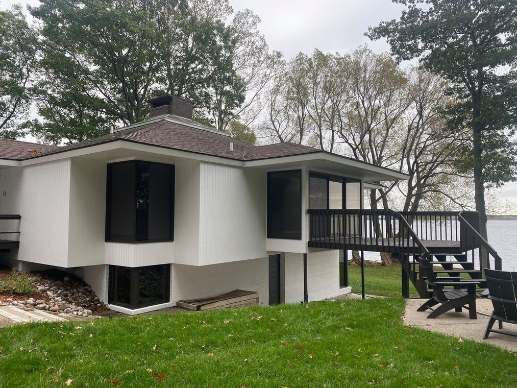 This is an image from Creations by Brian LLC company, located in Muskegon, MI The image is a modern lakefront home with fresh white exterior paint and dark trim, completed by Creations by Brian LLC