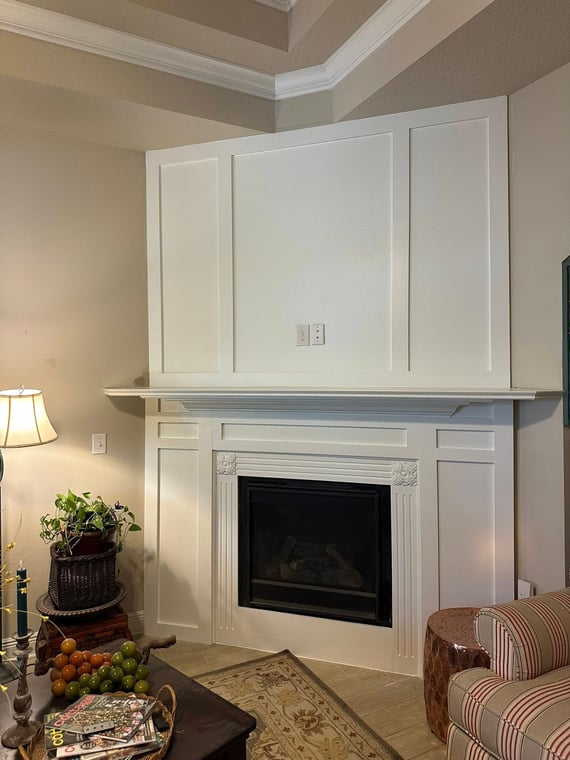 This is an image from 2T Touch Ups company, located in Freeport, FL. The image is a refinished living room fireplace with crisp white paneling and decorative trim, showcasing interior painting and millwork by 2T Touch-Ups