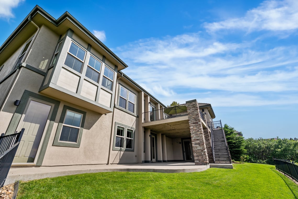This is an image from Parker Precision Painting Company, located in Parker, CO The image is a  two-story home with freshly painted beige exterior and green trim by Parker Precision Painting, highlighting professional residential exterior painting services.