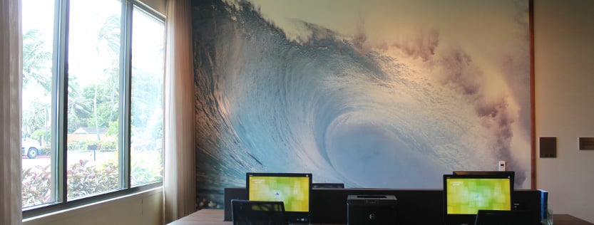 wall mural of an ocean wave displayed in a computer area.