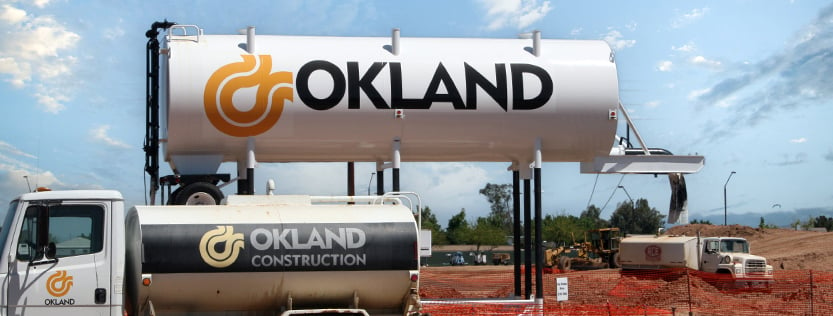 Okland Construction vinyl graphics on a large water tank and truck tanker.