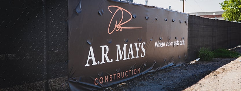 Black fence wrap logo banner for A.R. Mays Construction company.