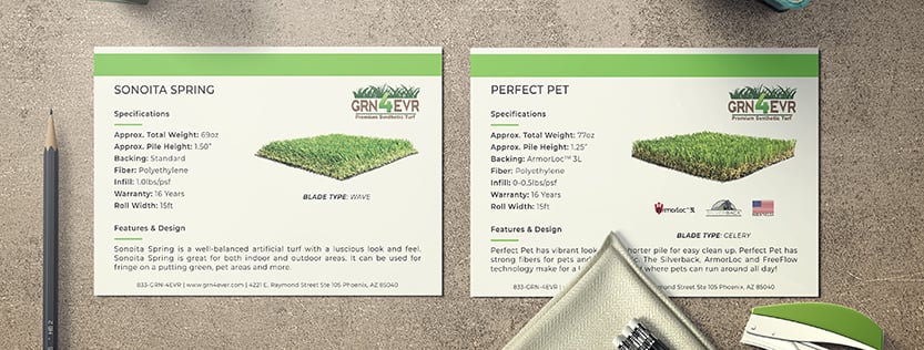 Postcards for the turf company Grn 4 Evr displayed on a desk top surface.
