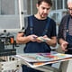 2 men at at print shop looking over color samples