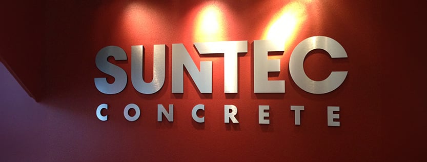 Dimensional cut letters of the Suntec Concrete logo hung on an office wall.