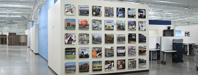 A variety of square prints on MDO displayed on a white wall.