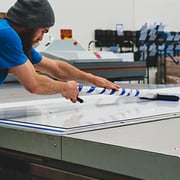 Man putting finishing touches on a large format printing project