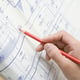 Person with a pencil looking over a blueprint