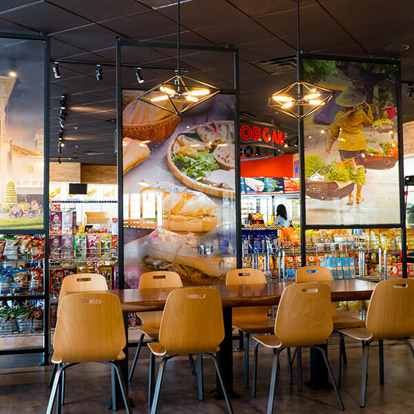 Table with 8 chairs in front of Interior signage and graphics at a restaurant.