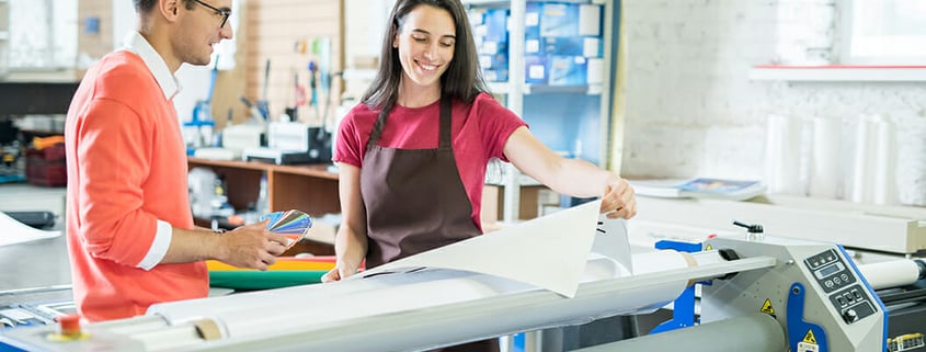 man and woman look at print in a commercial print company