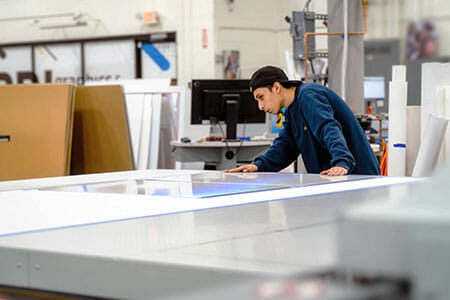 print operator monitoring the printing on a flatbed machine careers in commercial printing