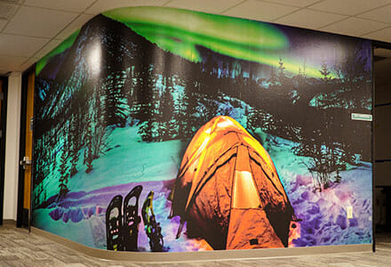 Curved wall wrap displaying a campsite with the northern lights in the sky.