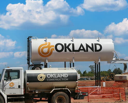 Construction company vinyl graphics showing the company logo for Okland on the sides of tankers