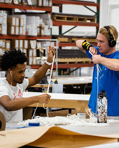 Two young men working in a warehouse listening to music.