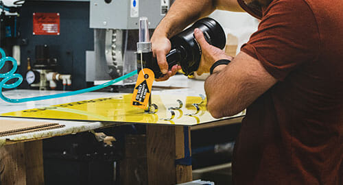 Man using power drill on a sign.