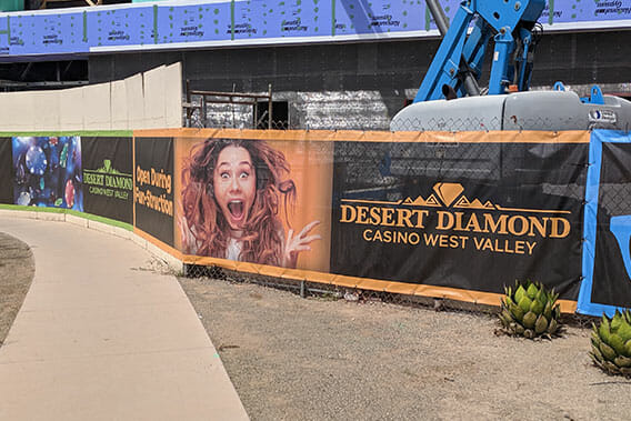 Construction fence wrap banner displaying advertising for new casino.