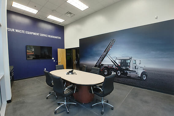 Boardroom with large wall coverings of a tandem truck in a open field.