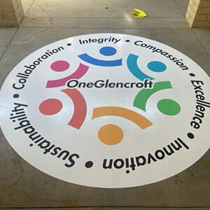 Large circular floor decal for OneGlencroft installed on cement entryway
