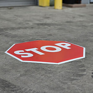 Floor decal stop sign installed on concrete outside warehouse doors