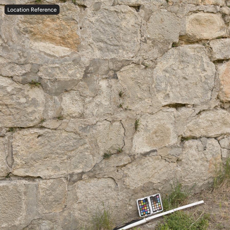 Silně opotřebovaný kamenný blok s plevelnou strukturou stěny