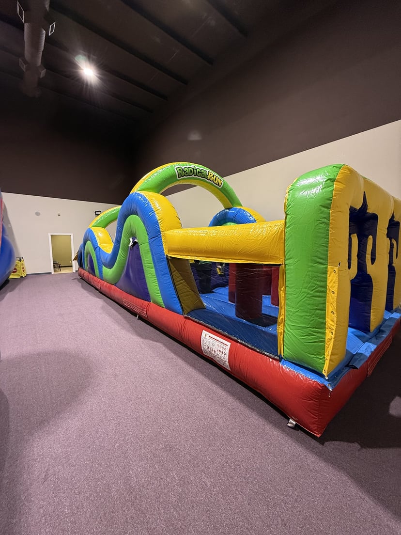 Kids climbing and racing through the 40ft indoor inflatable obstacle course at Central Arkansas Inflatables