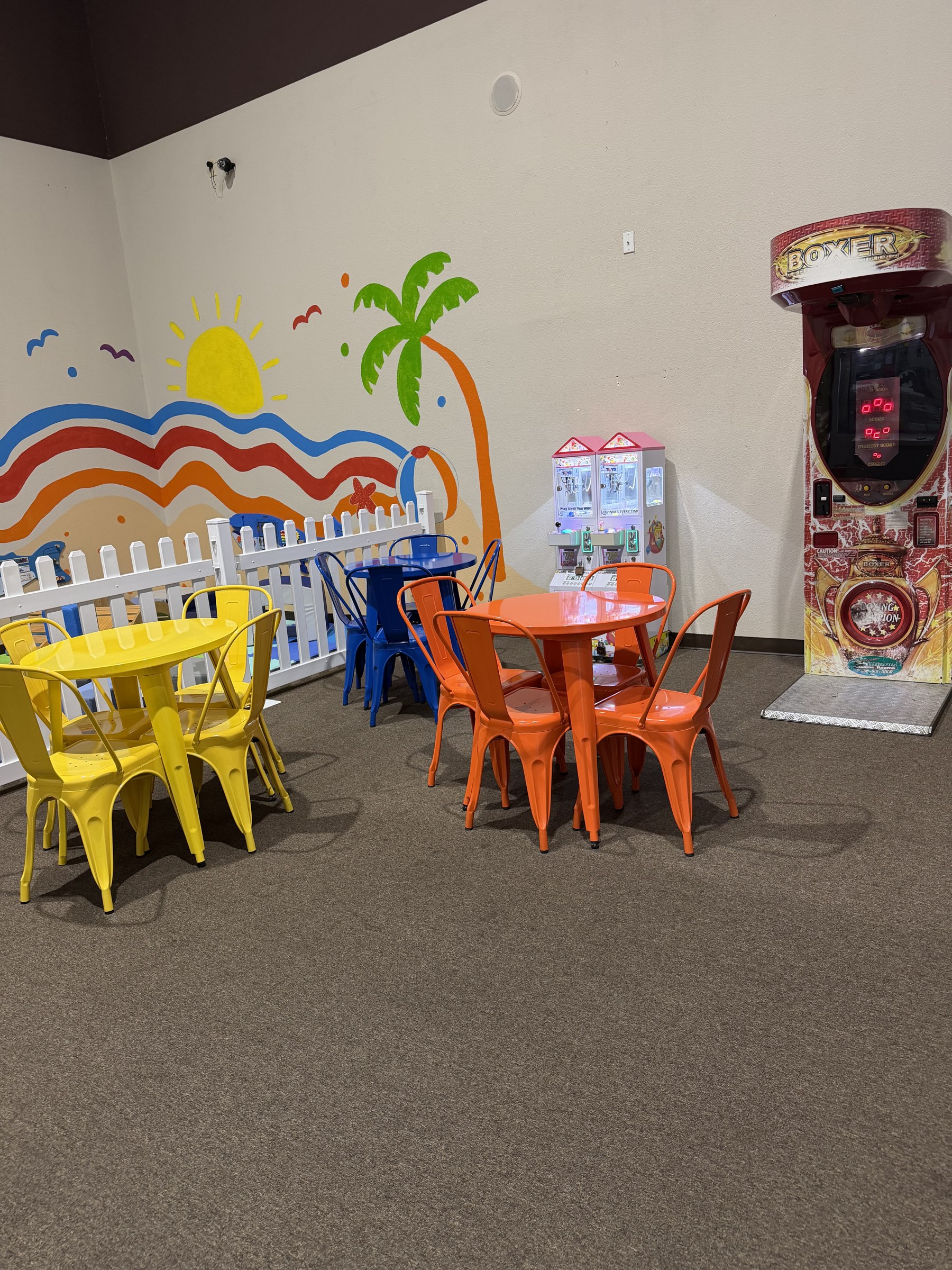Bright, freshly set up toddler soft play area with padded climbing shapes and a slide, gated separately from the big inflatables at Central Arkansas Inflatables in Bryant, AR