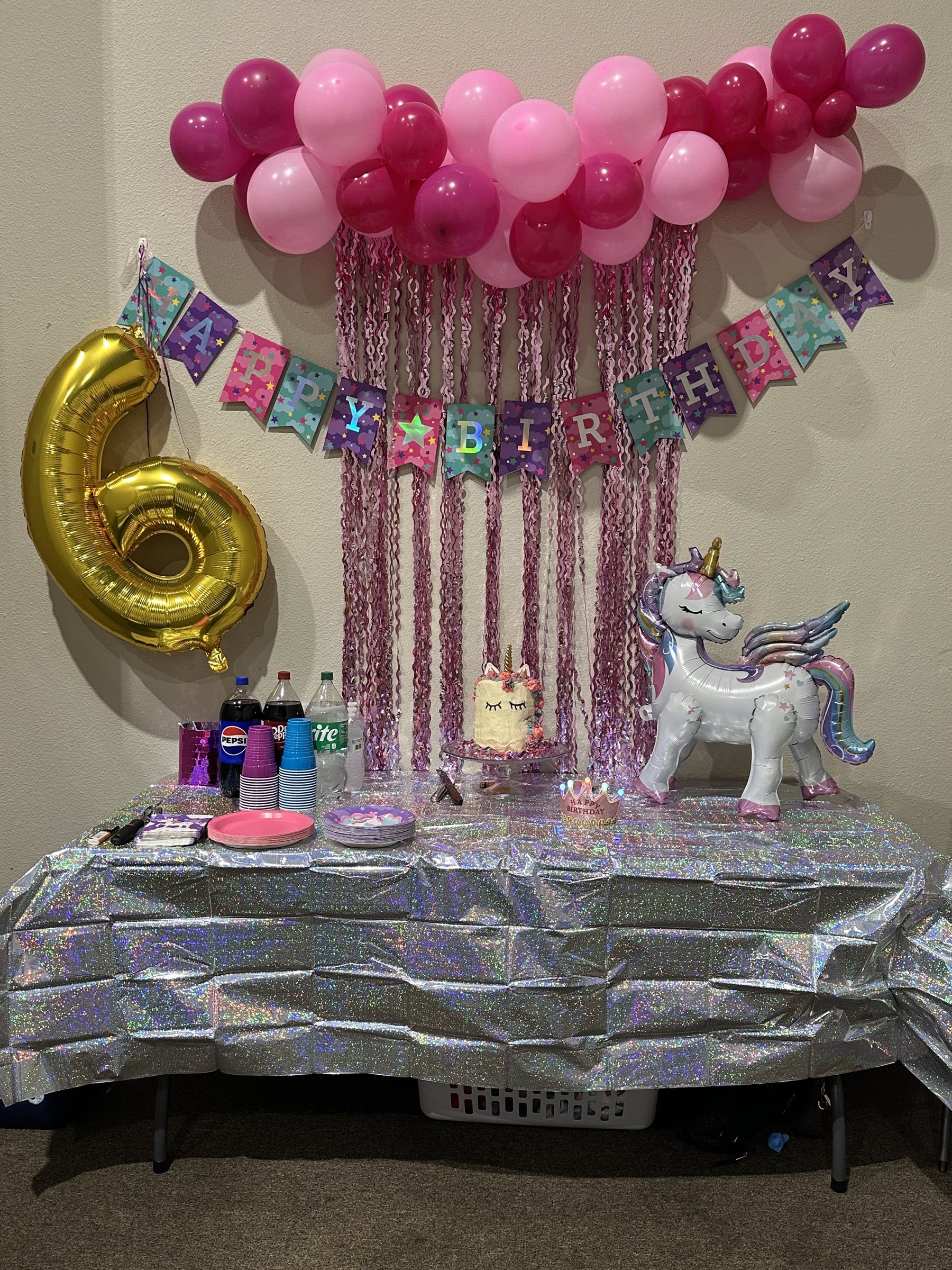 Pink and gold unicorn 6th birthday party room with balloon decorations