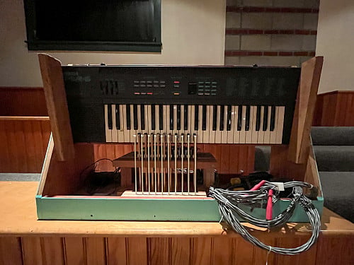 Keyboard on wooden stand with cables