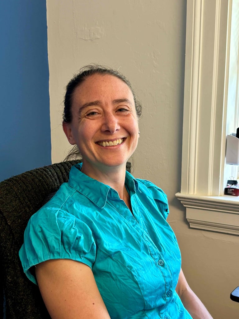Smiling woman in blue shirt.