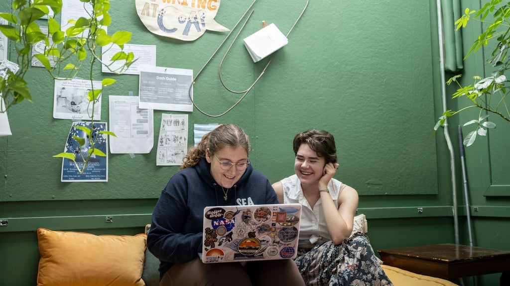 Two people working on a laptop.