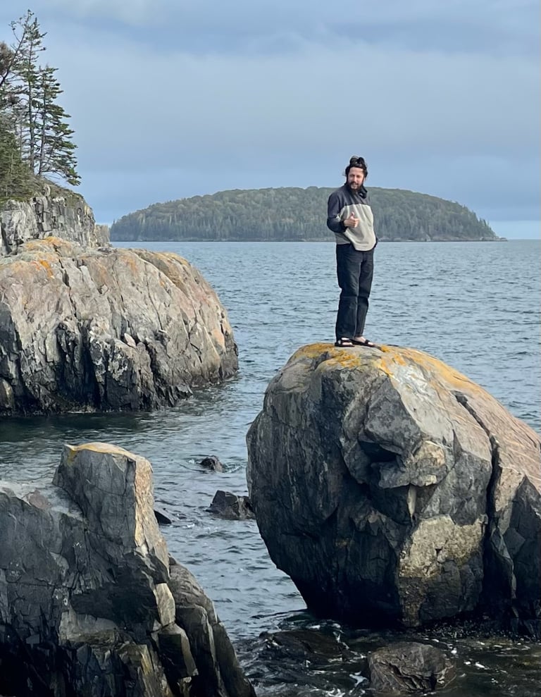 connor obrien standing on a rock by the ocean