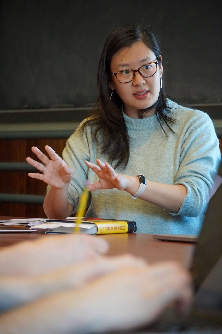 Person gesturing during classroom discussion.