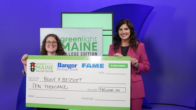 two people stand holding a giant check