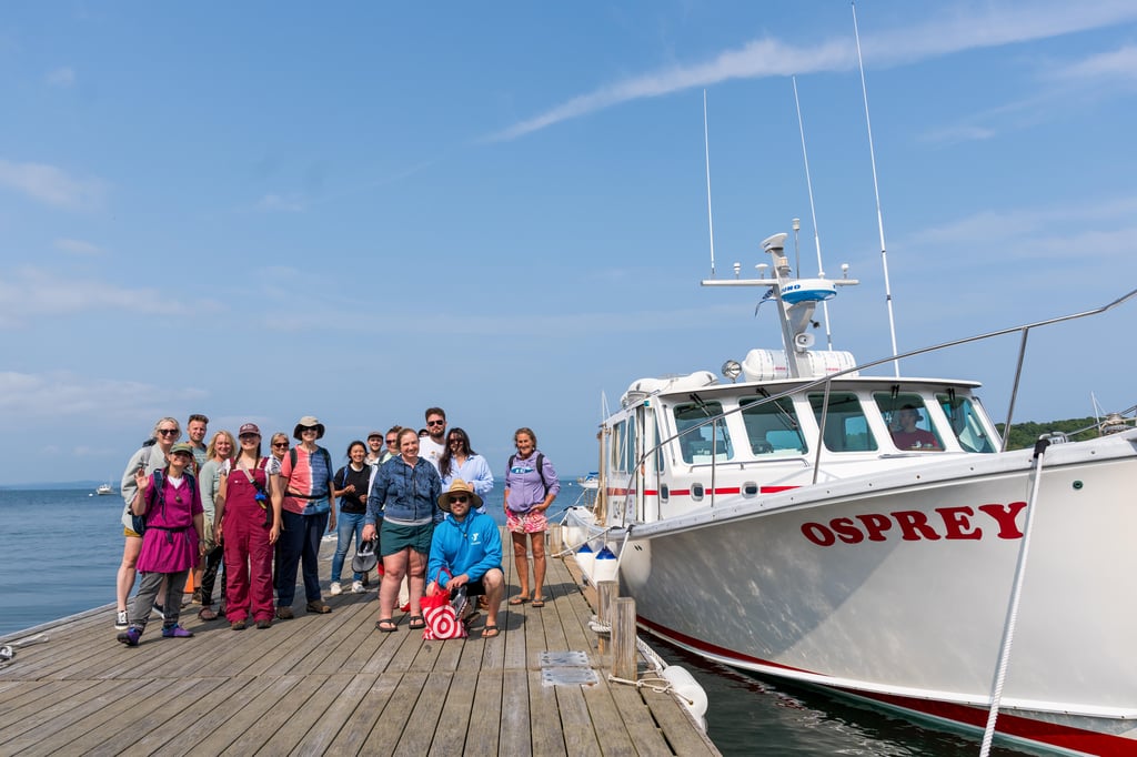 alumni pose near osprey