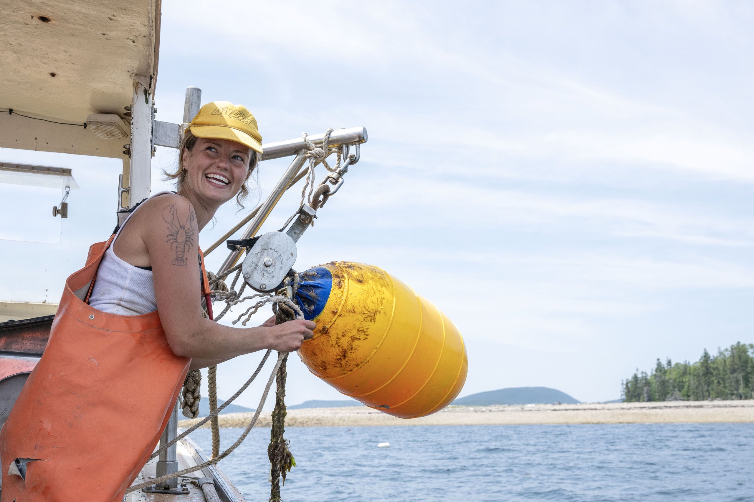 a woman pulling up a buoy into her boat