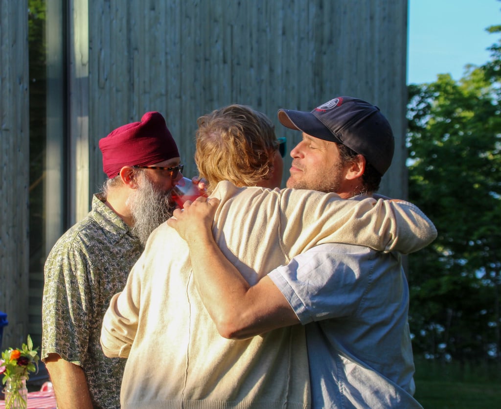 Three people sharing a warm embrace.