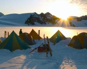 Tents in snowy mountain landscape at sunrise