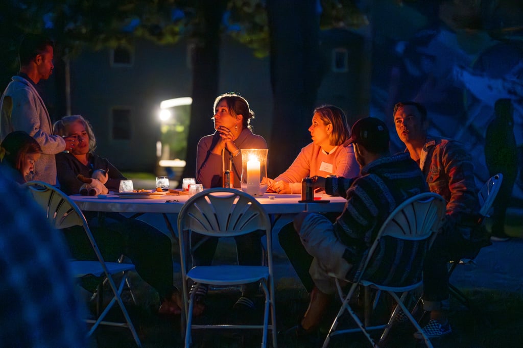 alumni sitting at a table by candlelight