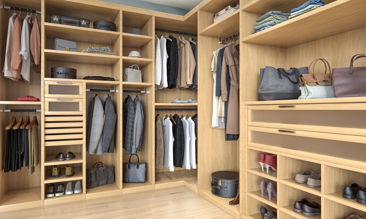 Custom walk-in closet with light wood, shelving, hanging rods, drawers, and shoe storage