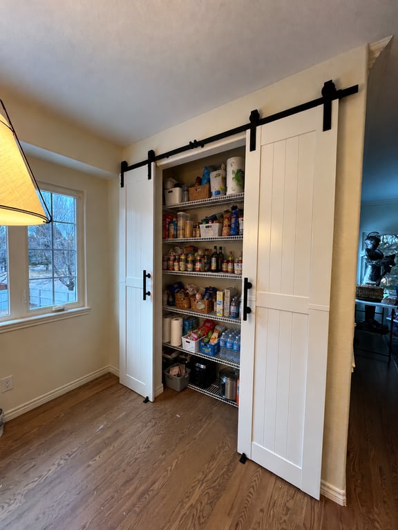 Cluttered Pantry Behind Barn Doors