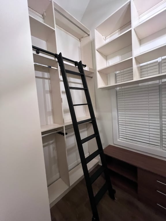 White Walk-In Closet with Library Ladder and Built-In Bench