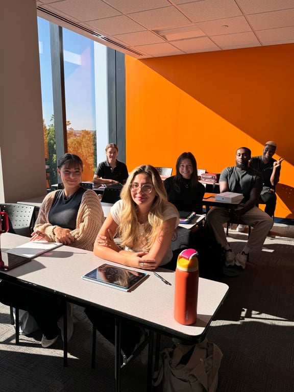Students smiling in a sunlit CAHE classroom