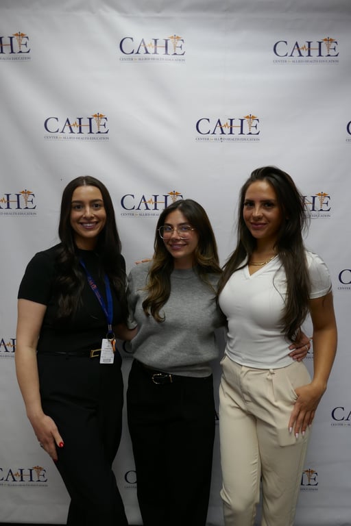 Students in professional attire network with healthcare employers at a CAHE job fair.