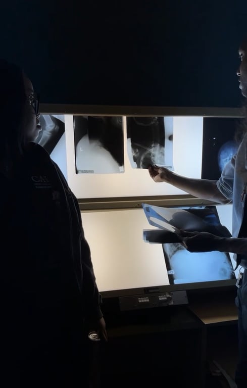 A radiography lab session at CAHE with X-ray equipment and students in scrubs.