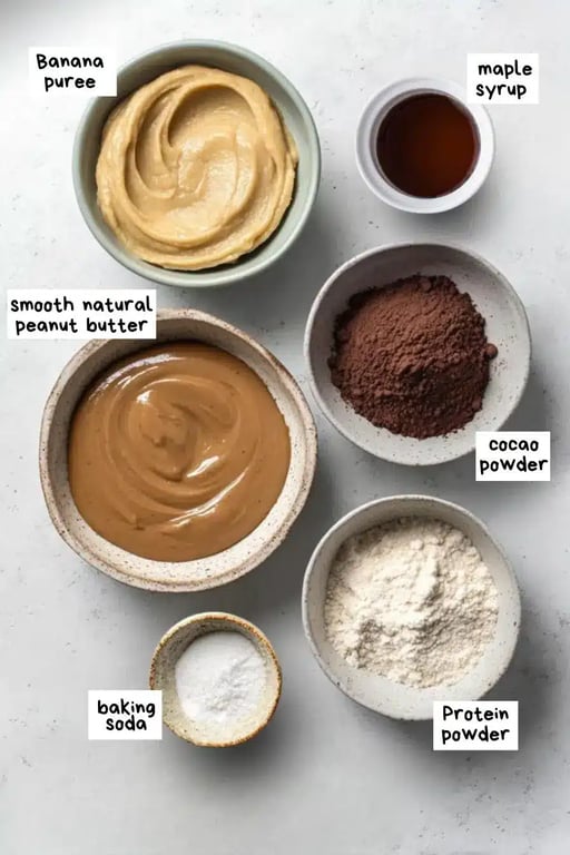 Vegan Protein Brownies – A Rich, Guilt-Free Treat You’ll Crave 7 Flat lay of vegan brownie ingredients in bowls including banana, protein powder, and cocoa.