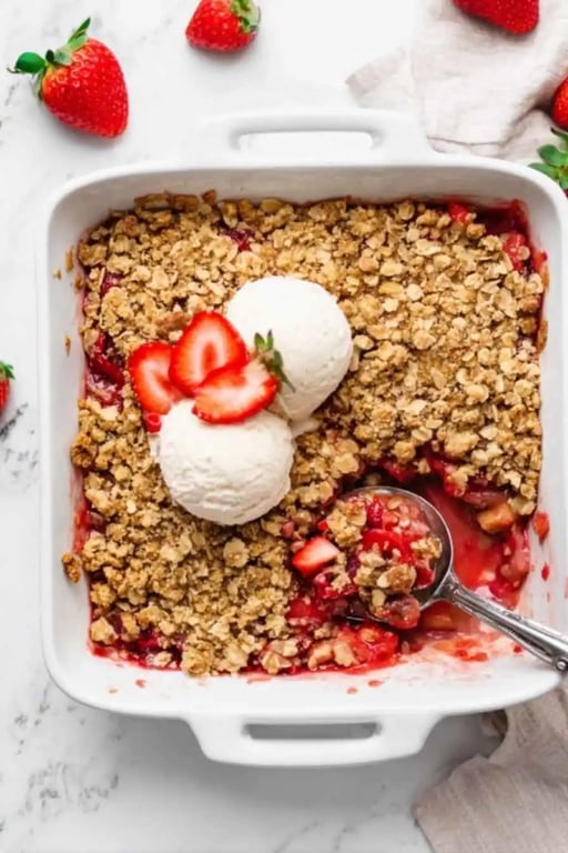 Healthy Strawberry Crisp – A Protein-Packed Summer Dessert 1 Healthy strawberry crisp topped with vanilla ice cream and fresh strawberries in a white baking dish.