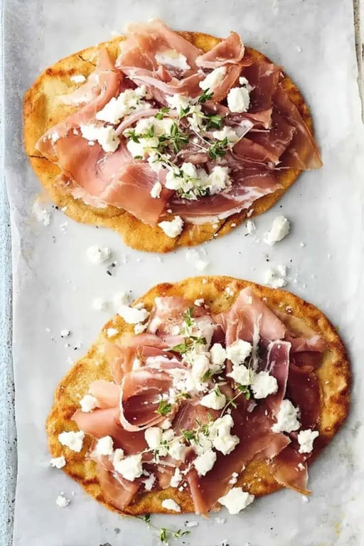 Freshly baked keto flatbread on a rustic wooden board with garlic butter and herbs