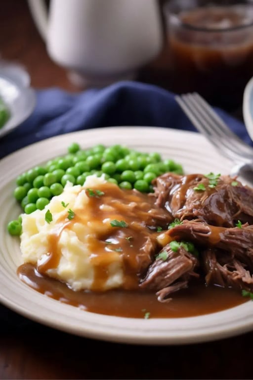 Mashed potatoes with gravy, beef, and green peas on a dinner plate