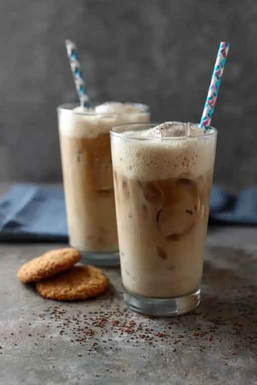 Two glasses of iced protein coffee served with cookies